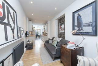 The oak flooring and inset, exposed brick wall add warmth and character to the living space.