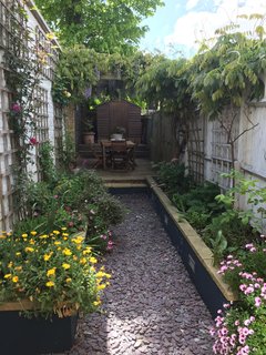 The 45-foot garden is low maintenance and has a feeling of seclusion and privacy, with a dining area enclosed by a pergola overhung with wisteria.