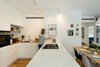 Modern home with Kitchen, Refrigerator, Drop In Sink, Wall Lighting, Wood Counter, White Cabinet, Open Cabinet, Ceiling Lighting, Medium Hardwood Floor, Wood Cabinet, Quartzite Counter, Dishwasher, and Wall Oven. The Open Kitchen and Dining Table Photo of The Flea Market Apartment