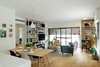 Modern home with Living Room, Storage, Shelves, Table, Chair, Coffee Tables, Bookcase, Ceiling Lighting, Wall Lighting, Medium Hardwood Floor, and Sofa. View from the entrance to the Living Room Photo 5 of The Flea Market Apartment