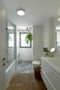 Modern home with Bath Room, One Piece Toilet, Marble Counter, Ceiling Lighting, Drop In Tub, Wall Lighting, Drop In Sink, Ceramic Tile Wall, and Ceramic Tile Floor. The Main Bathroom Photo 6 of The Flea Market Apartment