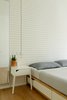 Modern home with Bedroom, Ceiling Lighting, Night Stands, Bench, Storage, Medium Hardwood Floor, Wardrobe, Lamps, and Bed. The Master Bedroom Photo 7 of The Flea Market Apartment