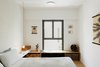 Modern home with Bedroom, Medium Hardwood Floor, Night Stands, Bench, Lamps, Storage, Ceiling Lighting, and Bed. The Master Bedroom Photo 8 of The Flea Market Apartment