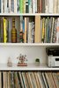 Modern home with Living Room, Ceiling Lighting, Bookcase, Medium Hardwood Floor, Shelves, and Wall Lighting. The Books and Records Library Photo 13 of The Flea Market Apartment