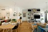 Modern home with Living Room, Lamps, Coffee Tables, Medium Hardwood Floor, Bookcase, Ceiling Lighting, Table, Wall Lighting, Shelves, Sofa, Chair, and Storage. The Living Room Photo 2 of The Flea Market Apartment