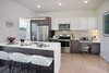 Modern home with Kitchen, Laminate Cabinet, Quartzite Counter, Refrigerator, Range, Ceiling Lighting, Laminate Floor, Microwave, Recessed Lighting, White Cabinet, Dishwasher, Porcelain Tile Backsplashe, Pendant Lighting, and Undermount Sink. 1177 @Greystone Kitchen Photo 6 of 1177 @Greystone