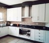 Modern home with Kitchen, Stone Tile Backsplashe, White Cabinet, Ceiling Lighting, Range Hood, Wall Oven, Granite Counter, Ceramic Tile Floor, and Cooktops. 20 year old kitchen units revamped with new white satin duco shaker doors and panels. Photo 3 of Botha Modern Shaker Kitchen