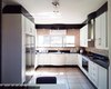 Modern home with Kitchen, Ceiling Lighting, Stone Tile Backsplashe, Refrigerator, White Cabinet, Drop In Sink, Granite Counter, Ceramic Tile Floor, and Cooktops. 20 year old kitchen units revamped with new white satin duco shaker doors and panels. Photo 4 of Botha Modern Shaker Kitchen