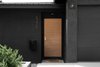 Modern home with Exterior, Stucco Siding Material, Gable RoofLine, and Mid-Century Building Type. The dark facade is contrasted by Pom Pom olive trees and a warm solid wood door with brass Emtek hardware Photo 2 of Raber By VEIN