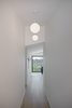 Modern home with Hallway and Light Hardwood Floor. The formal entry hallway is accented by an angular ceiling with pendant globe lights. Photo 5 of Raber By VEIN