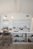 Modern home with Kitchen, Marble Counter, Light Hardwood Floor, White Cabinet, Wood Cabinet, Pendant Lighting, Drop In Sink, Ceiling Lighting, and Stone Slab Backsplashe. Open light oak shelves built into the island provide extra storage for the living room. Photo 8 of Raber By VEIN