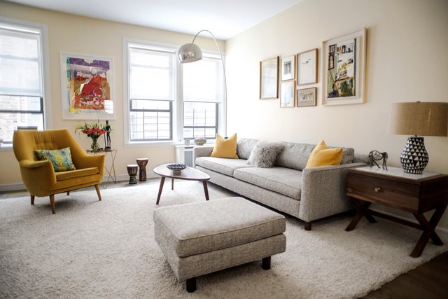Gray and yellow with a pop of red in the newly furnished living room with gallery wall