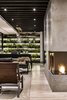 Modern home with Living Room, Sofa, Pendant Lighting, Light Hardwood Floor, Ceiling Lighting, Corner Fireplace, and Chair. A vertical garden decorates the far end of the dining room. Photo 6 of Apartment in Ahuehuetes Norte