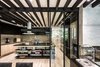 Modern home with Kitchen, Ceiling Lighting, Light Hardwood Floor, Stone Tile Backsplashe, Wood Cabinet, Granite Counter, and Drop In Sink. A set of fine glass doors connects the kitchen with the dining room Photo 8 of Apartment in Ahuehuetes Norte