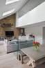 Modern home with Living Room, Track Lighting, Chair, Coffee Tables, Accent Lighting, Light Hardwood Floor, Bench, Bookcase, Ceiling Lighting, Sofa, and Recessed Lighting. The Pentagonal-shaped double height of the Olympia Loft, with the Master bedroom en-suite above that can see through a full width internal glazing the open-plan living areas below Photo of Olympia Loft
