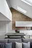 Modern home with Living Room, Sofa, Track Lighting, Chair, Console Tables, End Tables, Light Hardwood Floor, Bench, Ceiling Lighting, Accent Lighting, Coffee Tables, and Recessed Lighting. A straight view through the Living-Dining-Kitchen areas, with the upper balcony above and the sloped roof Photo 2 of Olympia Loft