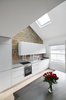 Modern home with Kitchen, Light Hardwood Floor, Engineered Quartz Counter, Refrigerator, Dishwasher, Accent Lighting, Range Hood, White Cabinet, Recessed Lighting, Track Lighting, Cooktops, Undermount Sink, and Ceiling Lighting. The Kitchen with its linear layout that maximizes the depth of the adjacent Dining area Photo 6 of Olympia Loft