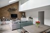 Modern home with Living Room, Chair, Bench, End Tables, Ceiling Lighting, Sofa, Accent Lighting, Recessed Lighting, Console Tables, Light Hardwood Floor, Track Lighting, and Coffee Tables. Diagonal view of the Living areas from the Dining Photo 17 of Olympia Loft