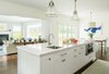 Modern home with Kitchen, Drop In Sink, Granite Counter, Dishwasher, White Cabinet, Medium Hardwood Floor, Ceiling Lighting, and Pendant Lighting. Our client wanted to furnish her home with a blue and grey color scheme, but didn’t want her new space to be stifled by this preference. To keep the home from feeling sterile, we incorporated heavily-textured accessories, fabrics, and rugs. And to contrast the modern with the familial, primary-colored art pieces were set against larger, neutral furnishings. Photo 4 of Contemporary Westchester Home
