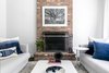 Modern home with Living Room, End Tables, Coffee Tables, Standard Layout Fireplace, Dark Hardwood Floor, and Sofa. For the den, Urszula opted for clean symmetry by taking advantage of two light gray sofas placed parallel to each other to create conversation areas and a clear walking path with the fireplace and framed black and white print working as the rooms main focal point. Photo 6 of Revitalized Old Greenwich Home
