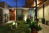 Modern home with Outdoor, Stone Fences, Wall, Grass, Trees, Garden, Flowers, Wood Patio, Porch, Deck, Hanging Lighting, and Tile Patio, Porch, Deck. Courtyard Photo 3 of COME IN! Family is in the courtyard