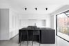 Modern home with Kitchen, Ceiling Lighting, White Cabinet, Concrete Floor, and Undermount Sink. The sleek, updated kitchen features glazed backsplashes, and the minimalist counters and cabinets are made of Fenix Laminate (Arpa). Photo 5 of Bessborough Residence