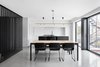 Modern home with Dining Room, Table, Concrete Floor, Pendant Lighting, and Chair. The kitchen bookends an open-plan layout that also includes a dining area and living room. Full-height windows help create a sense of spaciousness and open the living areas to the backyard. Photo of Bessborough Residence