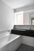 Modern home with Concrete Floor and Undermount Sink. White square ceramic tiles cover the bathroom walls. The counters are Fenix Laminate (Arpa). Photo 12 of Bessborough Residence