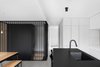 Modern home with Kitchen, Ceiling Lighting, Concrete Floor, Refrigerator, White Cabinet, and Undermount Sink. The sleek gray volume next to the kitchen houses utilities and a bathroom. Photo 10 of Bessborough Residence