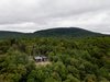 Modern home with Exterior, Cabin Building Type, Metal Roof Material, Wood Siding Material, and Shed RoofLine. The cabin has raw concrete foundations set upon the rocky cape. Photo 5 of La Binocle