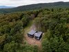 Modern home with Exterior, Wood Siding Material, Metal Roof Material, Cabin Building Type, House Building Type, and Shed RoofLine. La Binocle is segmented into two volumes that reach outwards towards the tree canopy. Photo of La Binocle