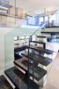 Modern home with Staircase, Stone Tread, and Glass Railing. The multi-level house has two kitchens and numerous gathering areas. High ceilings, walls of windows and skylights give the sleek interior a sense of spaciousness. Photo 3 of Via Victoria