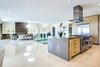 Modern home with Kitchen, Range, Refrigerator, Wood Cabinet, Recessed Lighting, Range Hood, and Ceiling Lighting. Clean modern lines and a white and cream color scheme enhance the aura of a home built for the southern California lifestyle. Photo 6 of Via Victoria