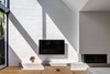 Modern home with Living Room, Sofa, Ottomans, Medium Hardwood Floor, Coffee Tables, Floor Lighting, Corner Fireplace, Gas Burning Fireplace, Ceiling Lighting, and Console Tables. Double height living space opens to the North. The use of reclaimed bricks adds textural diversity. Photo 3 of Cloud House