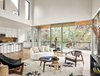 Modern home with Living Room, Medium Hardwood Floor, Coffee Tables, Sofa, Stools, Rug Floor, Chair, Ceiling Lighting, Recessed Lighting, and Bar. View of living area, kitchen, and outdoor porch by Low Design Office Photo 3 of Guadalupe River House