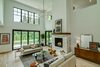 Modern home with Living Room, Lamps, Stools, Accent Lighting, Coffee Tables, Sofa, Ceiling Lighting, Table Lighting, End Tables, Standard Layout Fireplace, Ottomans, Light Hardwood Floor, Gas Burning Fireplace, and Console Tables. Dorchester Interior Great Room Photo 8 of The Dorchester Project by Paul + Jo Studio