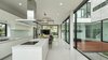 Modern home with Kitchen, Undermount Sink, Range Hood, Cooktops, Porcelain Tile Floor, Engineered Quartz Counter, Ceiling Lighting, and White Cabinet. Kitchen island connecting to courtyard Photo 9 of SIRI House