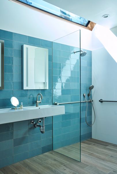 The bathroom can now accommodate a wheelchair if needed. The floor is slightly slanted so that any water that splashes will flow to the drain.