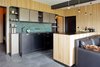 Modern home with Kitchen, Laminate Cabinet, Marble Backsplashe, Pendant Lighting, Undermount Sink, Slate Floor, Dishwasher, and Engineered Quartz Counter. In a mountain retreat in the Czech Republic near the border with Germany, Martina Schultes designed a kitchen that brings the outside in, with wood plank paneling used on the walls and the kitchen island. The island and countertops are topped with black laminate, and the backsplash is a green marble, which stands out against the back cabinets. Photo 2 of Mountain Apartment in Ore Mountain, Czech Republic