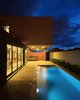 Modern home with Outdoor and Back Yard. Half of the terrain is left "empty", a longitudinal half void that varies in height, establishing an almost equal condition between covered space and open-air space. Photo 11 of QP House