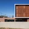 Modern home with Exterior, House Building Type, Wood Siding Material, Stucco Siding Material, and Flat RoofLine. If the ground floor free area constitutes an open but intimate area (closed from the street and surrounding views), the terrace in the upper floor creates a relation between the house and the landscape. Photo 3 of QP House