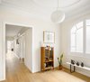Modern home with Hallway and Light Hardwood Floor. “The corridor was enlarged and the doors were replaced with large, white, lacquered wooden walls and sliding glass,” says designer Marina Sezam. Photo of Consell de Cent St, Eixample District