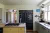 Modern home with Kitchen, Beverage Center, Range, Microwave, Refrigerator, Colorful Cabinet, Wall Oven, Dishwasher, Wood Counter, Drop In Sink, Recessed Lighting, and Light Hardwood Floor. Blackboard fronts make this refrigerator and shelves a great place to create art. Photo 3 of Modern Farmhouse