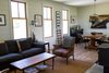 Modern home with Living Room, Sofa, Light Hardwood Floor, Wood Burning Fireplace, Ceiling Lighting, Coffee Tables, Chair, and Accent Lighting. Living room with wood burning stove, open dining area with stocked bar and piano art. Photo 5 of Modern Farmhouse