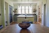 Modern home with Kitchen, Wall Oven, Recessed Lighting, Refrigerator, Colorful Cabinet, Pendant Lighting, Drop In Sink, Range, Dishwasher, Wood Counter, Light Hardwood Floor, Beverage Center, and Microwave. Dining area and kitchen. The heart of the home. Photo 7 of Modern Farmhouse