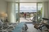 Modern home with Bedroom, Rug Floor, Ceiling Lighting, Recessed Lighting, Chair, Night Stands, Bed, and Dark Hardwood Floor. Floor to ceiling and wall to wall glass frames the view through a private deck. Photo 10 of Farwell