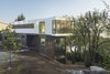 Modern home with Exterior, Concrete Siding Material, Tile Roof Material, Prefab Building Type, House Building Type, Wood Siding Material, Metal Siding Material, and Flat RoofLine. From the edge of the property the graceful entry and landscape gently slope around to a lower yard. Photo 3 of Farwell