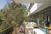 Modern home with Outdoor, Wood Patio, Porch, Deck, Gardens, Large Patio, Porch, Deck, Back Yard, Grass, Garden, Trees, Wire Fences, Wall, and Decking Patio, Porch, Deck. the expansive deck facing western view hunts the historic Madrona tree and is lined by floor to ceiling glass accessing the living spaces. Photo 8 of Farwell