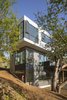 Modern home with Exterior, Flat RoofLine, Tile Roof Material, Wood Siding Material, Metal Siding Material, House Building Type, Concrete Siding Material, and Prefab Building Type. The house wraps itself around the historic tree while allowing the natural landscape to do the same around itself. Photo 15 of Farwell