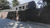 Modern home with Outdoor, Front Yard, Stone Fences, Wall, Horizontal Fences, Wall, Wood Fences, Wall, Landscape Lighting, Hardscapes, Walkways, and Vertical Fences, Wall. If you look at this object from the street for more than 1 minute, you notice the dissonance of patterns. Photo of The Grey House